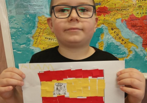 Chłopiec prezentuje flagę Hiszpanii.