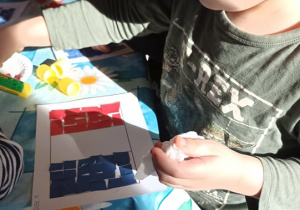 dzieci wyklejają flagę Francji papierwm kolorowym