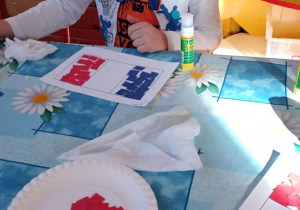 dzieci wyklejają flagę Francji papierwm kolorowym