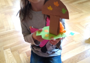 Dziewczynka prezentuje grzybka z papieru