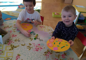 Dzieci wykonują pracę plastyczną - pizza z kolorowego papieru