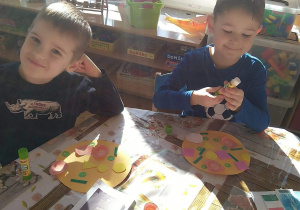 Dzieci wykonują pracę plastyczną - pizza z kolorowego papieru