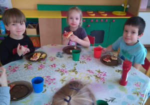 Dzieci zjadają przygotowana przez siebie pizzę