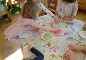 Dziecko układa obrazek z kolorowego makaronu