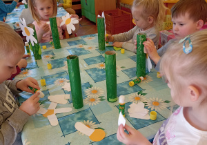 dzieci malują rolkę po ręczniku na zielono