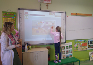 Dziewczynka wykonuje zadanie na tablicy interaktywnej