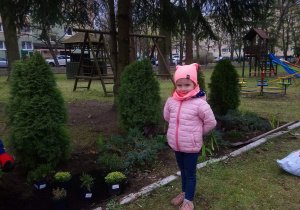 Honoratka pozuje do zdjęcia w ogródku przedszkolnym