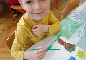 Chłopiec maluje farbami