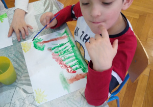Chłopiec maluje farbami