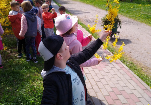 Dzieci pozują z gałązkami forsycji