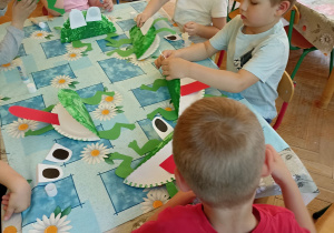 dzieci naklejają elementy w pracy żabka
