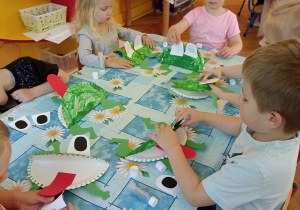 dzieci naklejają elementy w pracy żabka