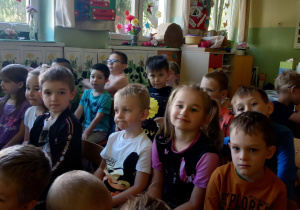 Dzieci przysłuchują się wykonawcom audycji muzycznej.