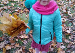 Dziewczynka trzyma bukiet z liści