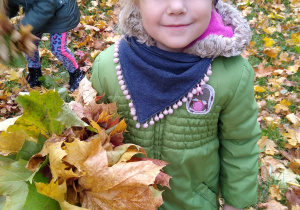 Dziewczynka trzyma bukiet z liści