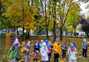 Dzieci podrzucają liście