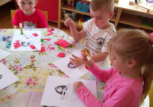 Dzieci kolorują kolorowanki z postaciami z czeskich bajek