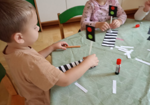 Dzieci wyklejają zebrę z papieru kolorowego