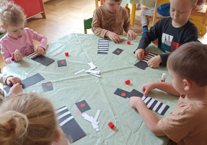 Dzieci wyklejają zebrę z papieru kolorowego