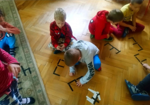 dzieci tworzą cyfry z pałeczek