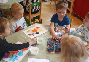 dzieci malują jesienne liście