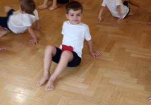 dzieci ćwiczą w kostiumach gimnastycznych
