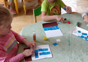 dzieci wyklejają papierem kolorowym