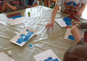 dzieci wyklejają papierem kolorowym