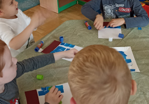 dzieci wyklejają papierem kolorowym