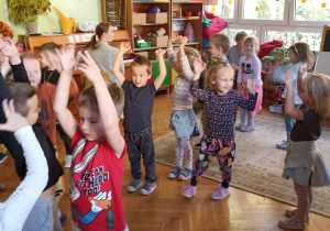 dzieci tańczą i unoszą ręce do góry
