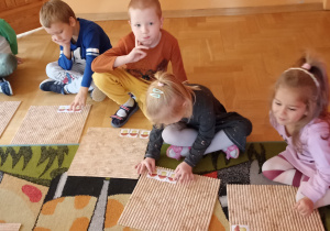 dzieci siedzą przed dywanikiem