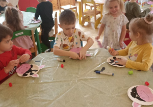 dzieci wyklejają papierem kolorowym talerzyk