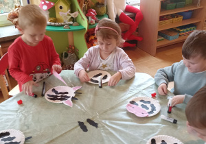 dzieci wyklejają papierem kolorowym talerzyk