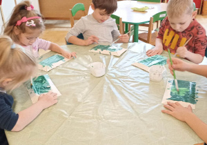 dzieci malują papierowe talerzyki