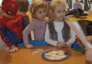 dzieci stoją przy stoliku