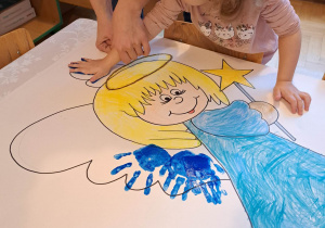 Dzieci wykonują pracę plastyczną "Aniołek"