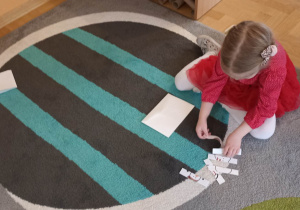 dzieci na dywanie układają puzzle