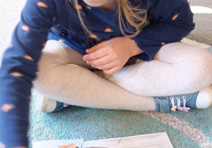 dzieci układają obrazek na dywanie