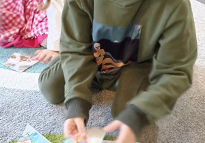 dzieci układają obrazek na dywanie