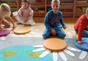 dzieci układają białe płatki kwiatka do kolorowego krążka