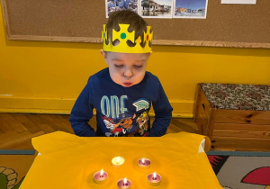 Chłopiec zdmuchuje urodzinowe świeczki