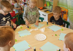 dzieci kolorują pastelami kolorowe listki