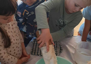 Dzieci mieszają składniki potrzebne na chleb