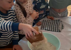 Dzieci mieszają składniki potrzebne na chleb