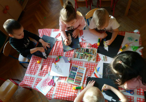 Dzieci wykonują prace przy stolikach