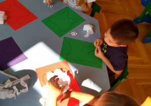 Dzieci wyklejają kontury bibułą