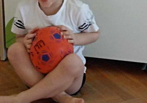 człopiec trzyma piłke