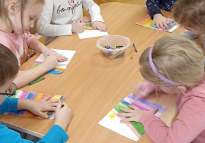 dzieci kolorują kartkę w kolorowe paski