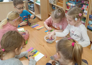 dzieci kolorują kartkę w kolorowe paski