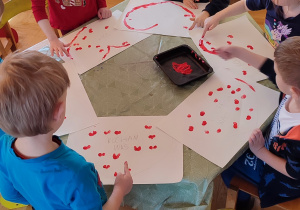Dzieci malują przy stolikach